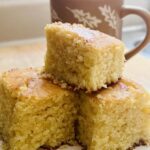 3 golden corn bread pieces with a mug in the background