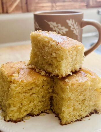 3 golden corn bread pieces with a mug in the background